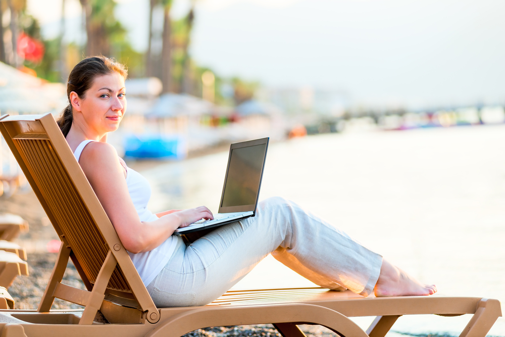 woman with laptop on beach
