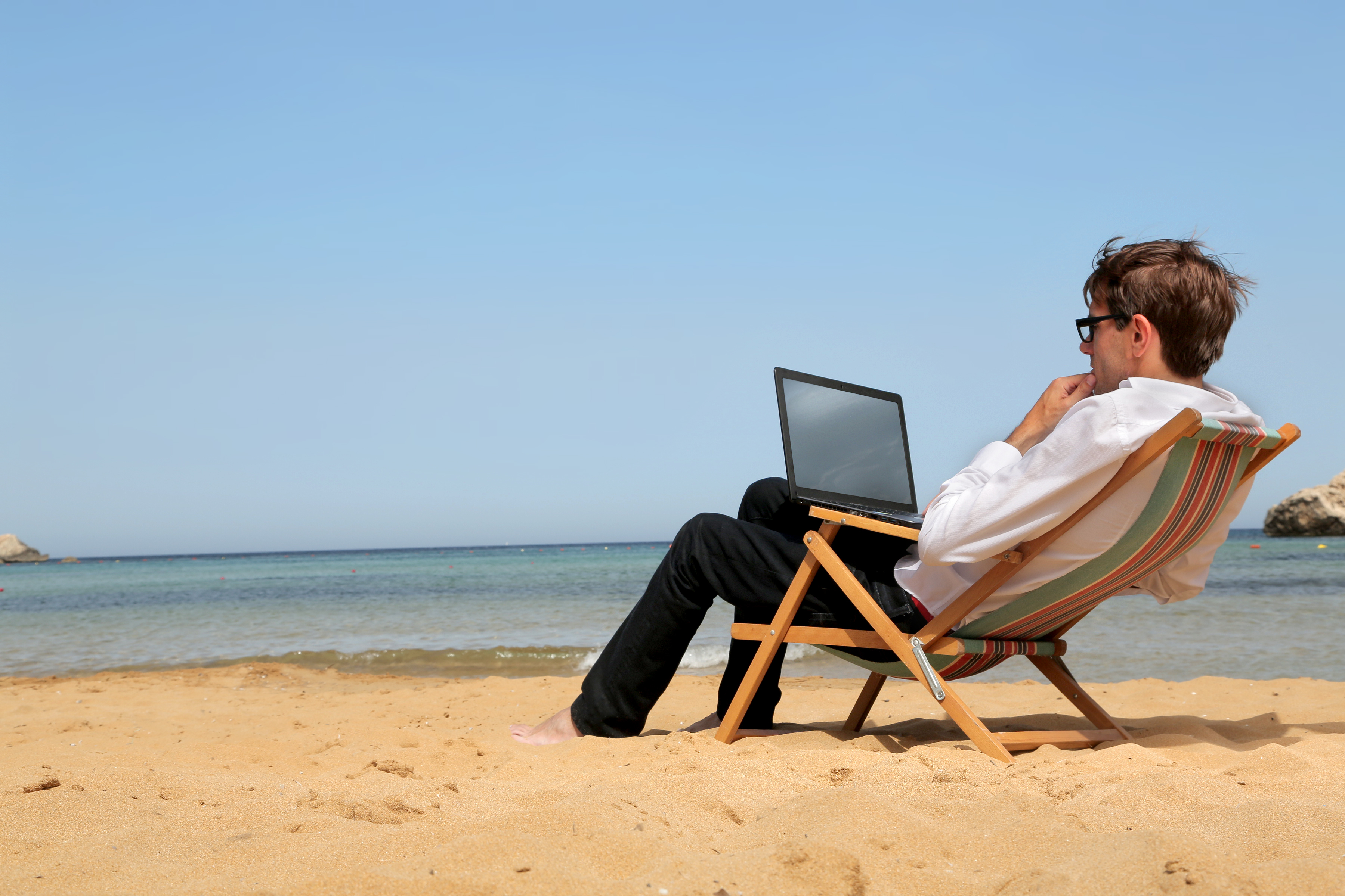 Как работать без отпуска. Человек с ноутбуком на пляже. Человек на шезлонге. Человек в отпуске. Отдыхающий человек на море.